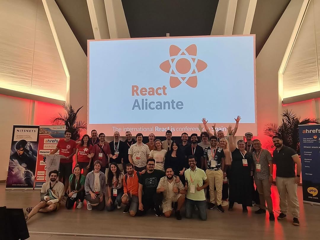 Speakers and attendees in the group photo on stage, 2024